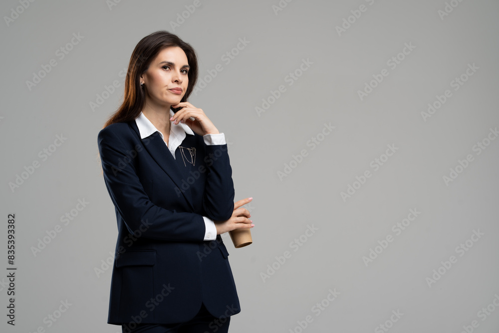 Woman in dress shirt and blazer, holding coffee cup in office Woman in dress shirt and blazer, holding coffee cup in office