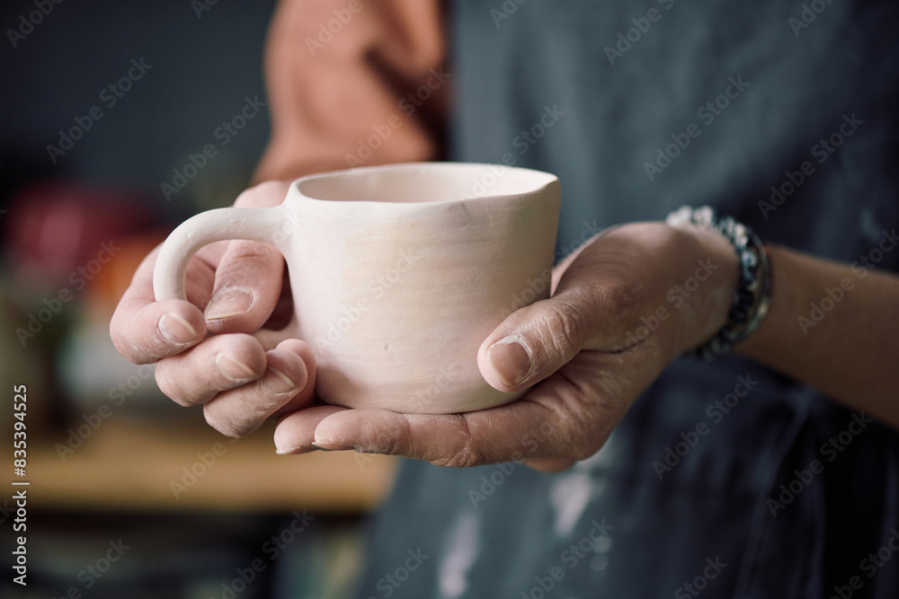 Closeup of hands of unrecognizable female potter holding handmade ceramic cup Closeup of hands of unrecognizable female potter holding handmade ceramic cup