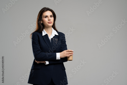 Woman in business attire with collar dress shirt, blazer, and holding coffee cup