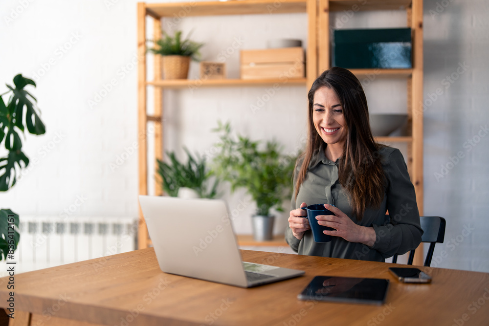 Young smiling businesswoman on coffee break in home office. Young smiling businesswoman on coffee break in home office.