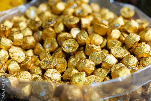Fototapeta Naklejka Na Ścianę i Meble -  Golden Wrapped Chocolates Glistening in Abundance