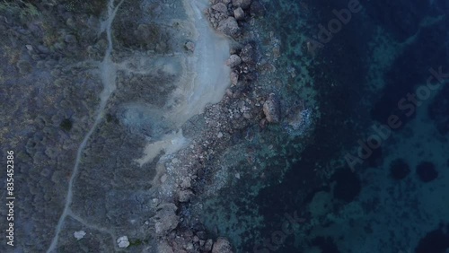 Aerial view of Rocky shore and emerald sea water still in the shade. Mediterranean sea, Malta Island, Ghajn Tuffieha Qarraba bay. High quality 4k footage photo