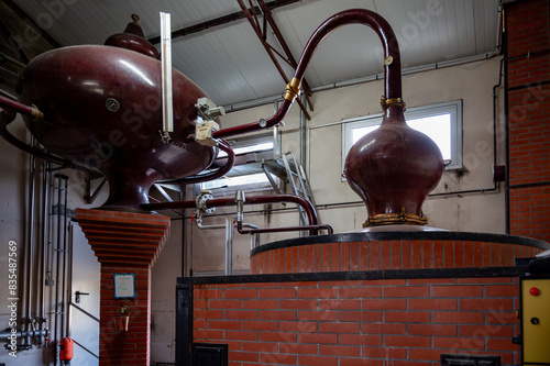Double distillation process of cognac spirit in Charentias copper alambic still pots and boilers in old distillery in Cognac white wine region, Charente, Segonzac, Grand Champagne, France