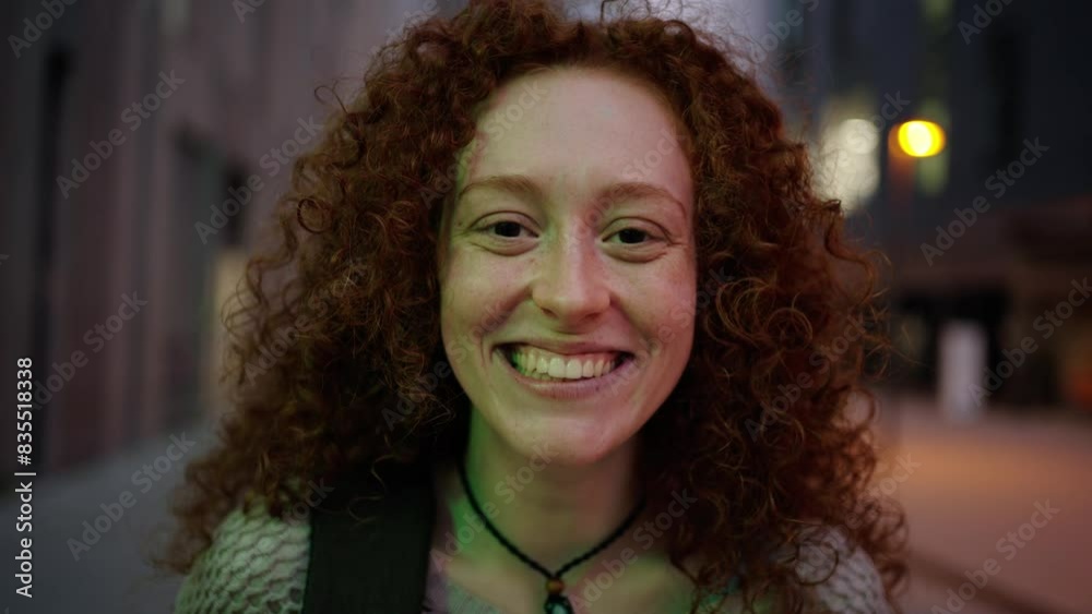 Close up portrait of a young redhead Caucasian student girl wearing backpack standing in front of the city work area building. Smiling and cheerful gesture looking up around. Inspirational shot Close up portrait of a young redhead Caucasian student girl wearing backpack standing in front of the city work area building. Smiling and cheerful gesture looking up around. Inspirational shot