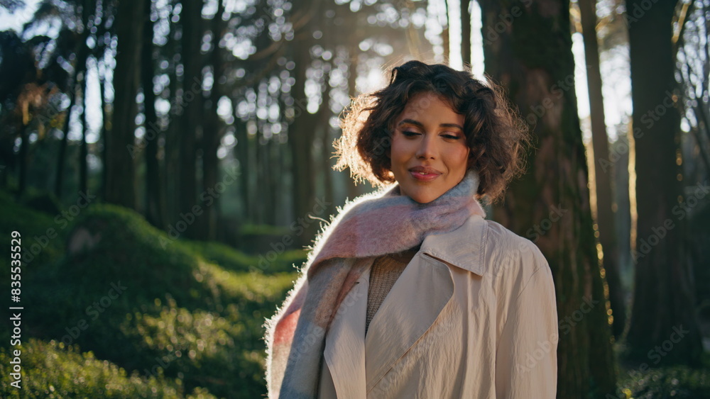Carefree woman smiling woods greenery sunlit by morning light closeup. Traveler Carefree woman smiling woods greenery sunlit by morning light closeup. Traveler