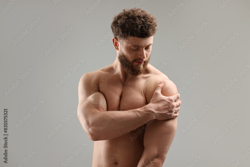 Handsome man with muscular body on light grey background Handsome man with muscular body on light grey background