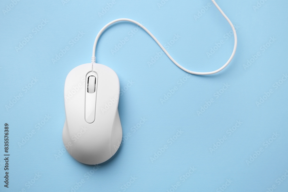 One wired mouse on light blue background, top view. Space for text One wired mouse on light blue background, top view. Space for text