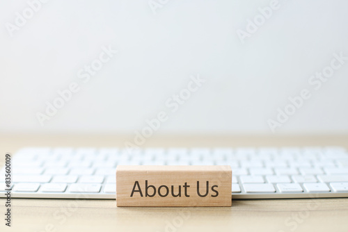 About Us Written On Woodenblock With Keyboard.