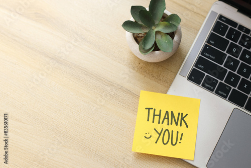 Top View Of Yellow Sticky Note Written Thank You on Laptop With Succulent Over Wooden Background