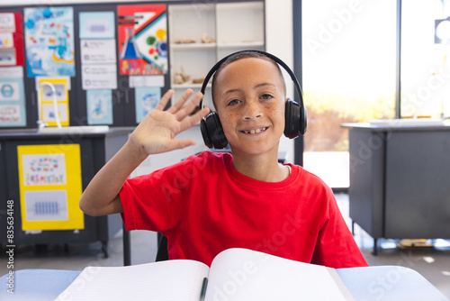 Biracial boy enjoys a learning session at school on a video call photo