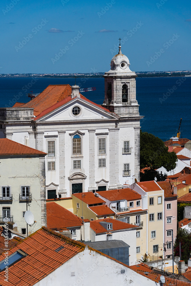 Fototapeta premium View of the beautiful skyline of Lisbon, Portugal, with red roofed, colorful houses in the Alfama district during a sunny day