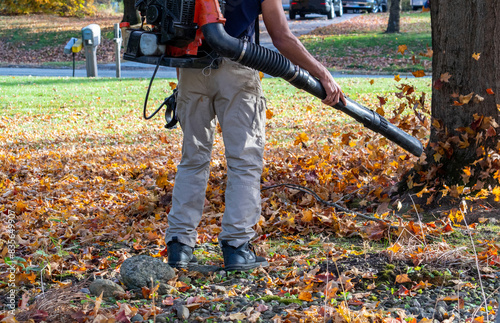 worker uses a leaf blower for fall clean up in a  Indiana yard