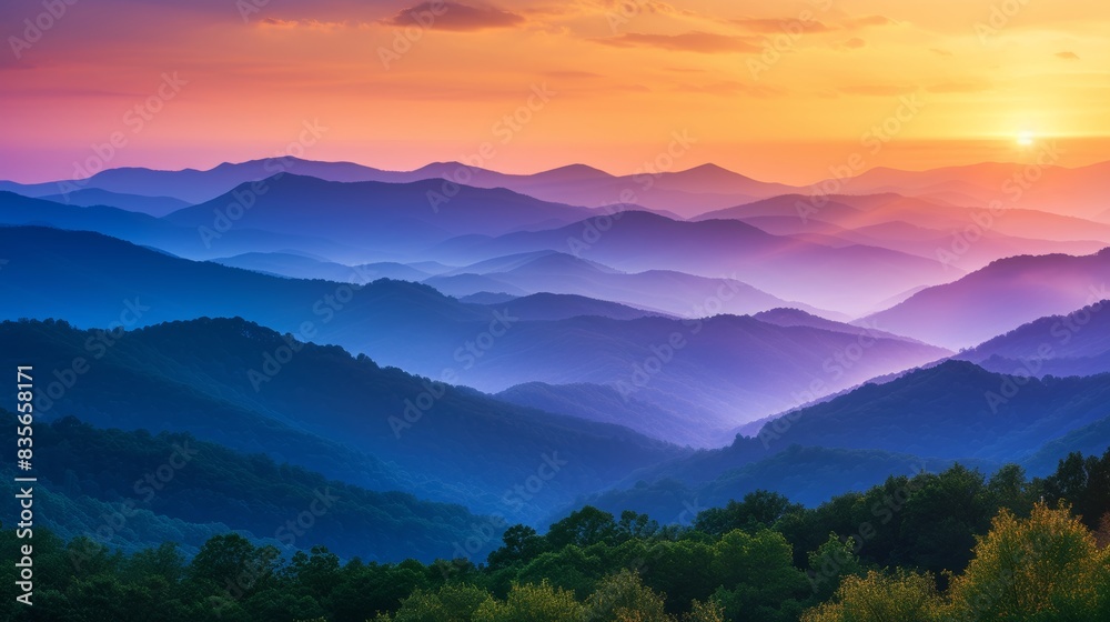 Fototapeta premium Sunset over misty mountain range with vibrant colors