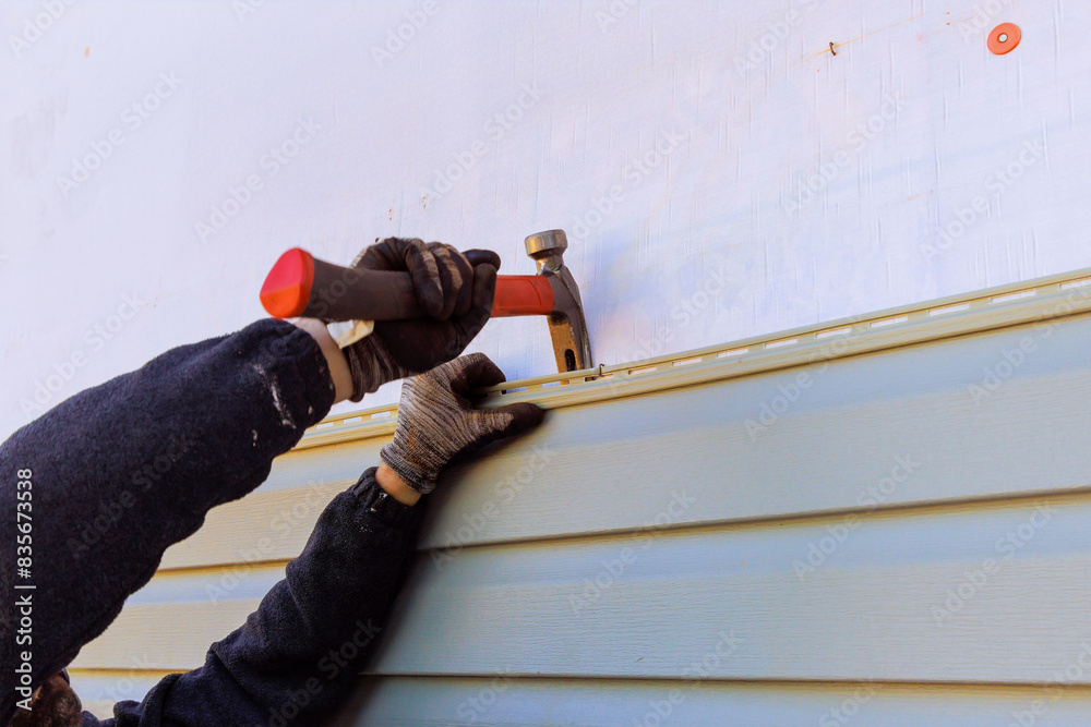 Damaged plastic siding of house is replaced during reconstruction of its exterior