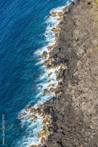 Waves crashing up against a rocky coast line next to the ocean