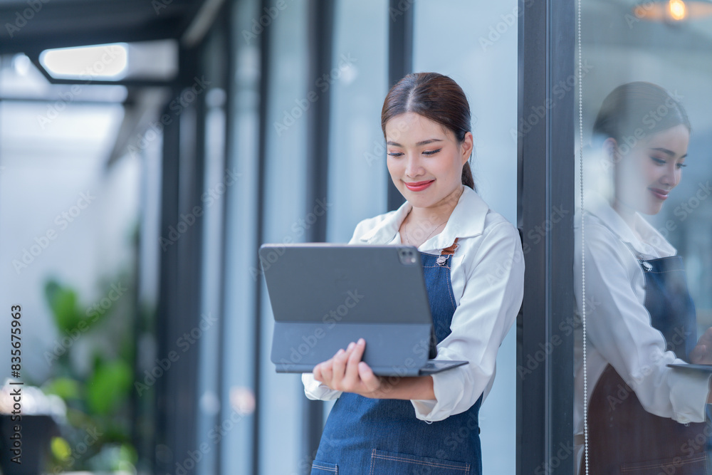 Startup successful small business owner sme beauty girl stand with tablet smartphone in coffee shop restaurant. Portrait of asian tan woman barista cafe owner. SME entrepreneur seller business concept Startup successful small business owner sme beauty girl stand with tablet smartphone in coffee shop restaurant. Portrait of asian tan woman barista cafe owner. SME entrepreneur seller business concept