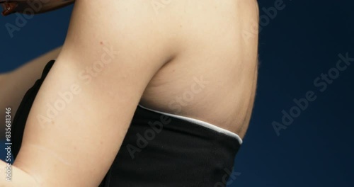 Violinist in black, plays against blue backdrop