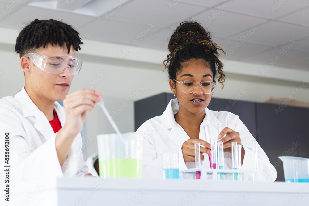 Teenage biracial boy and teenage undefined girl in a lab setting in high school Teenage biracial boy and teenage undefined girl in a lab setting in high school