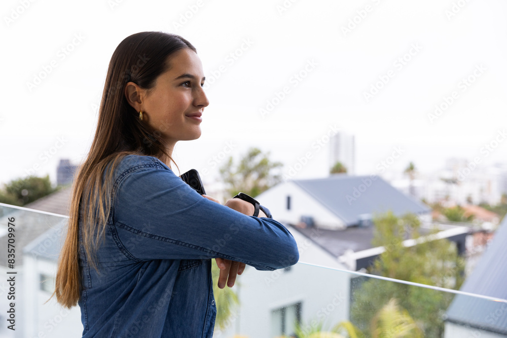 At home, young Caucasian woman relaxing on balcony, enjoying serene moment