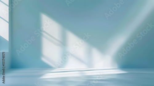 Minimalistic abstract gentle light blue background for product presentation with light and intricate shadow from window on wall.
