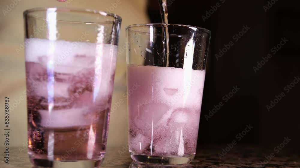 Close up of pouring red wine from bottle into goblet on dark color background wall in studio. Slow motion Close up of pouring red wine from bottle into goblet on dark color background wall in studio. Slow motion