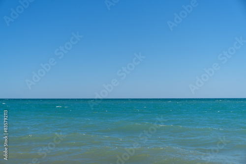 Blue sea  waves. Wave splashing over pebbles at sea. Rolling ocean waves. Summer paradise beach background. Powerful sea waves