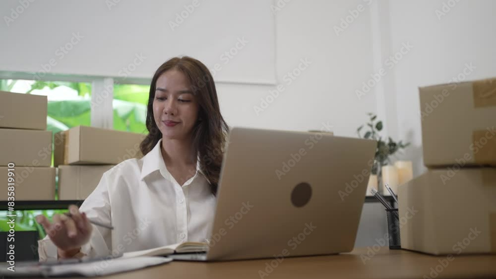 Young female entrepreneur is packing merchandise  at home.