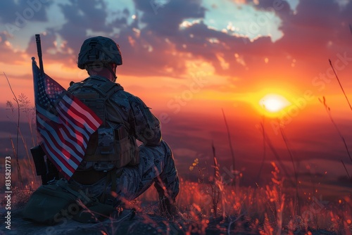 A soldier in uniform sits on a hillside watching a sunset, holding an American flag. The sky is painted with vibrant colors, reflecting peace.