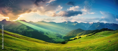 Landscape photography capturing a stunning summer mountain scene with lush green meadows, a rural road, a beautiful rainbow, and a dramatic sky providing a compelling copy space image. photo