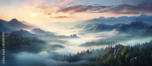 A stunning aerial view of a mountain peak surrounded by clouds at sunrise in summer, showcasing a beautiful landscape with rocky terrain, dense forests, and a cloudy sky, ideal for a copy space image.