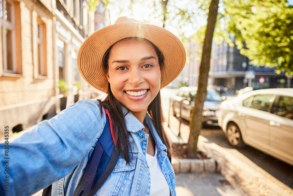 Happy woman with hat taking selfie during European city break