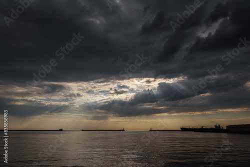 WEATHER ON THE SEA COAST - The last rays of sunlight and dramatic rain clouds over sea port