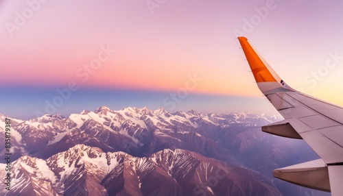 A view across a wing of a commercial plane flying the Himalayas, at dusk
 photo