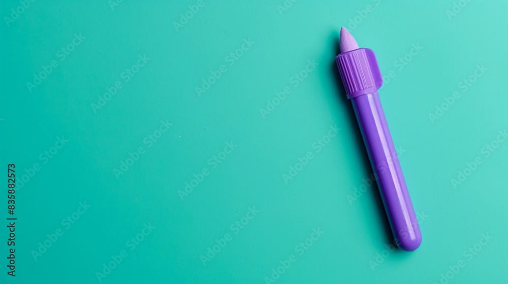 A purple glue stick in the top left corner of a solid teal background, ideal for arts and crafts. A purple glue stick in the top left corner of a solid teal background, ideal for arts and crafts.