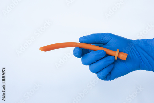 Holding nasopharyngeal airway tube isolated on white. NPA maintains airway patency in spontaneously breathing patients with intact gag reflexes.