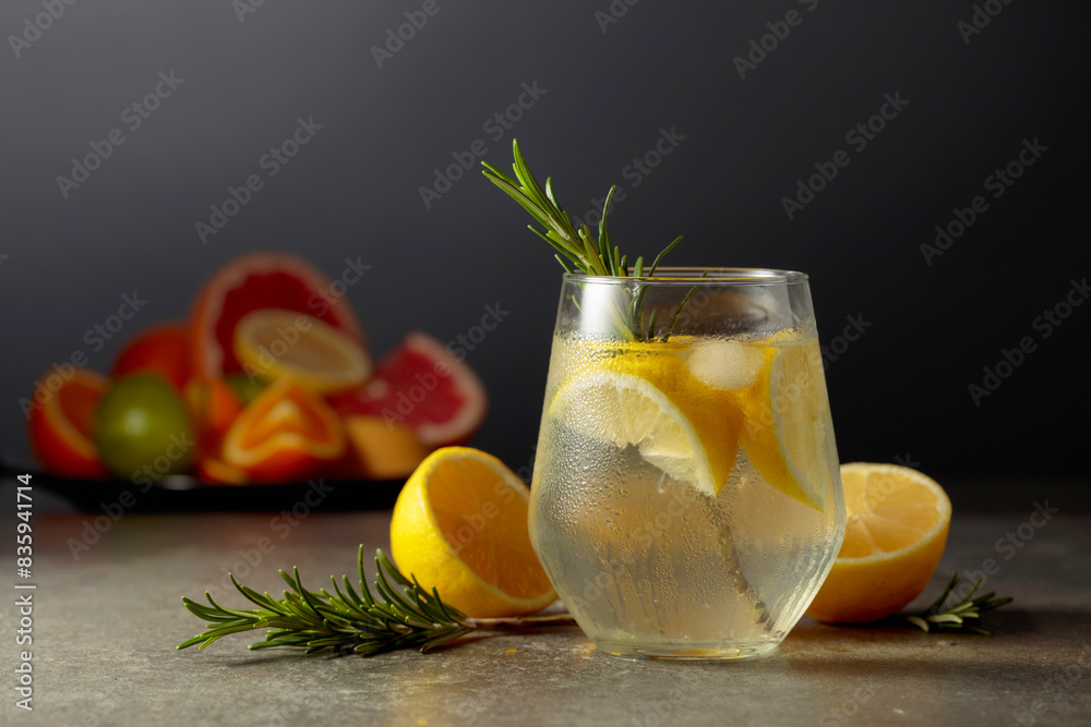 Cocktail gin tonic with ice, rosemary, and lemon on a stone table. Cocktail gin tonic with ice, rosemary, and lemon on a stone table.