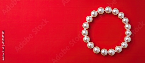 beautiful seawater pearl bracelet on a red background. Creative banner. Copyspace image
