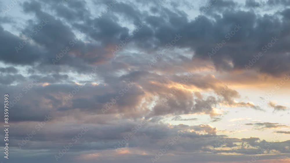 Timelapse of beautiful black clouds moving in the blue sky and the rays of the bright sun at sunset