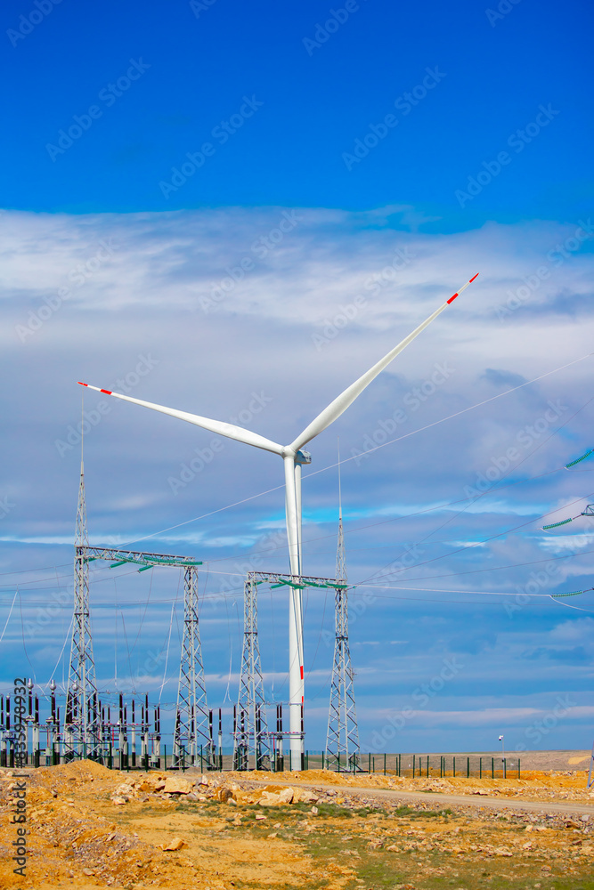 Fleet of power generators in motion. The blades of the wind farm rotate against the sky. The concept of extracting electricity from renewable sources. Wind turbine to generate electricity. Fleet of power generators in motion. The blades of the wind farm rotate against the sky. The concept of extracting electricity from renewable sources. Wind turbine to generate electricity.