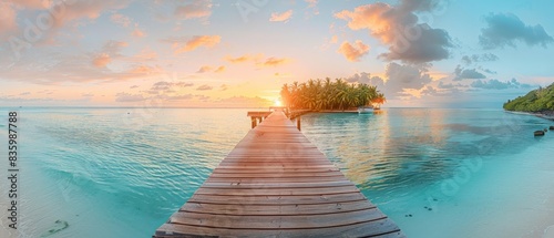 The photo shows a beautiful beach with a wooden dock jutting out into the calm water. The sky is a gradient of orange and yellow, and the sun is setting over the horizon. photo