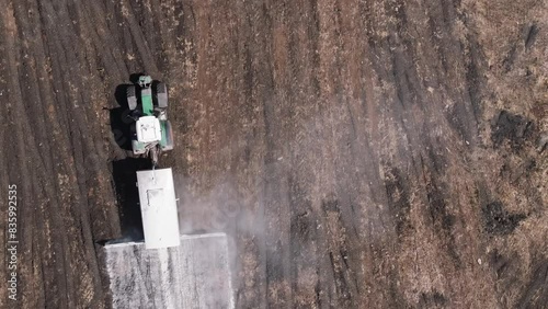 Top View Of A Farm Tractor Adding Lime To The Natural Soil In Agricultural Land. Aerial Shot