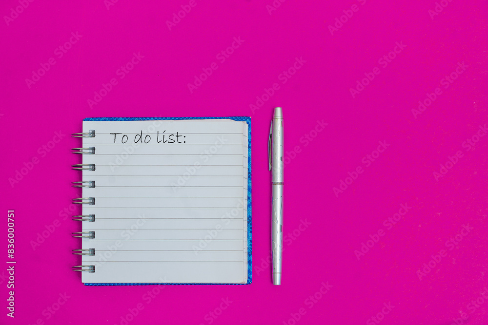 To do list on the pink table with pen. Planning and organization of work. Plat lay place for text To do list on the pink table with pen. Planning and organization of work. Plat lay place for text