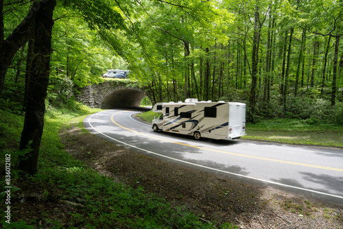 Recreation vehicles driving over and below an overpass along a mountain road through a forest, The Loop, Newfound Gap Road, Great Smoky Mountain National Park, Tennessee