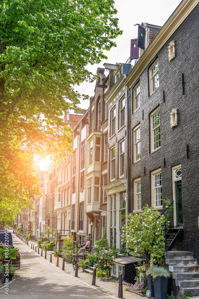 Fototapeta premium Amsterdam downtown old houses. Sunset in Amsterdam. Nice view of the famous city of Amsterdam. Travel to Europe. Amsterdam, Holland, Netherlands, Europe.