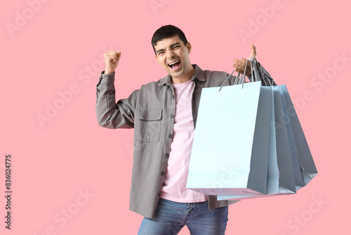 Happy young man with shoppi...