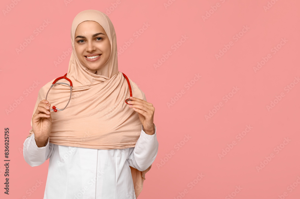 Portrait of female Muslim doctor with stethoscope on pink background Portrait of female Muslim doctor with stethoscope on pink background