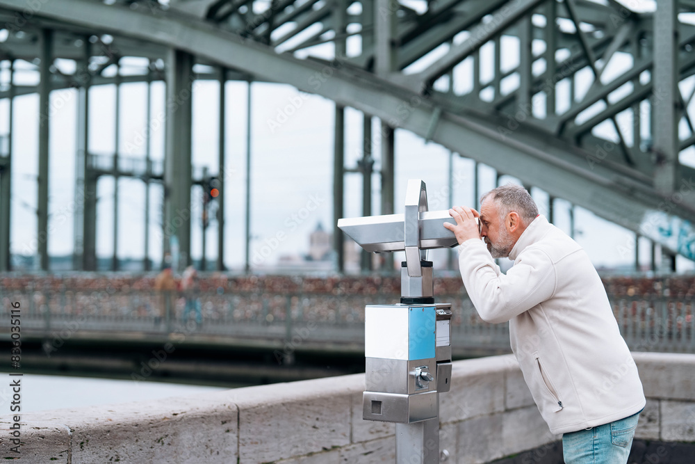 man looking through binoculars at city in Germany 