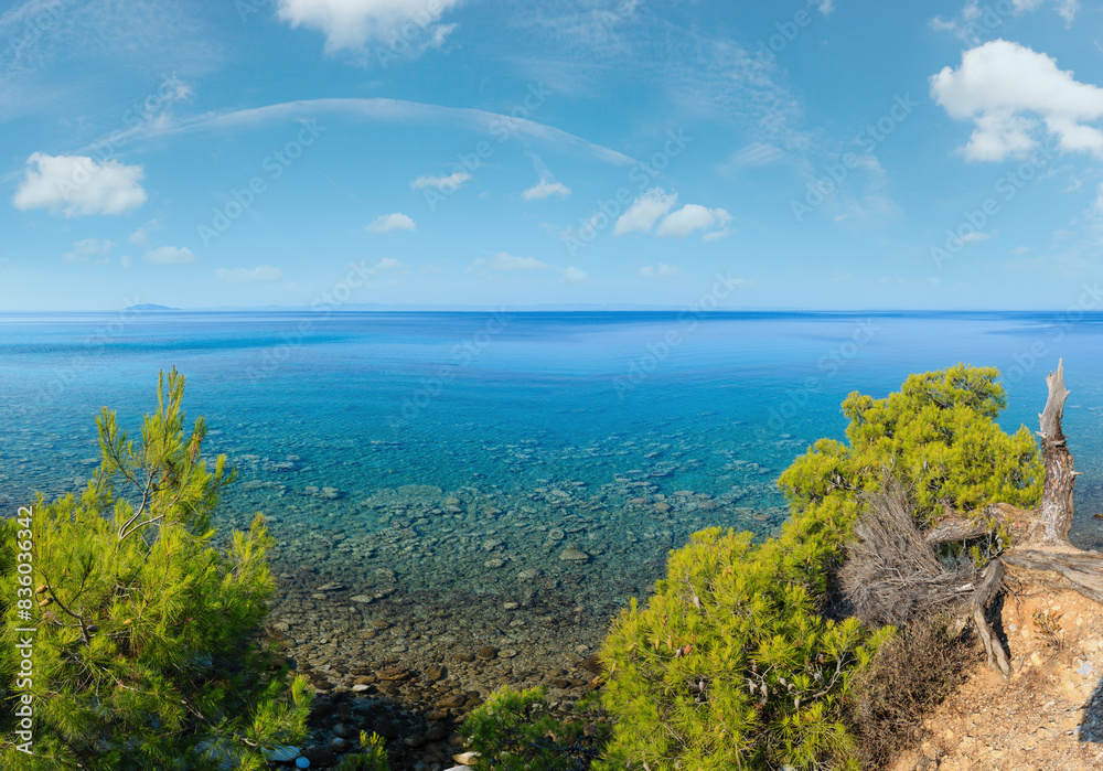 Morning summer Aegean Sea coast with pine tree on shore (Nikiti, Sithonia, Halkidiki, Greece). Two shots stitch panorama. Morning summer Aegean Sea coast with pine tree on shore (Nikiti, Sithonia, Halkidiki, Greece). Two shots stitch panorama.