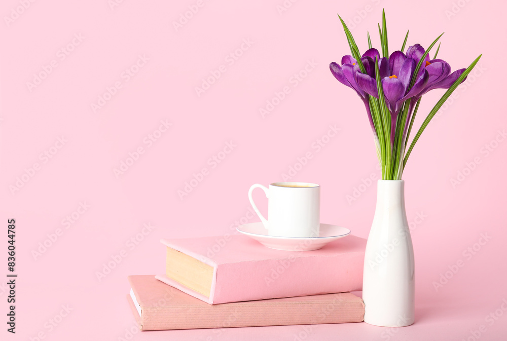 Obraz premium Vase with beautiful crocus flowers, cup of coffee and books on pink background