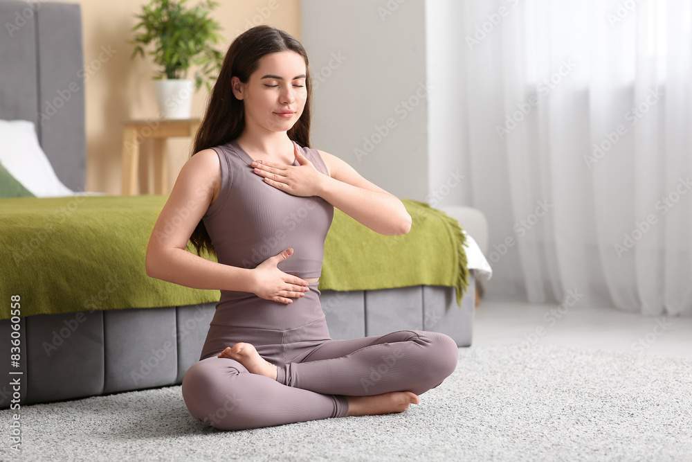 Pretty young woman doing breath practice at home Pretty young woman doing breath practice at home